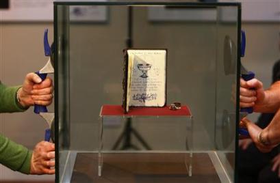 Library staff lift a glass case before containing one of only ...